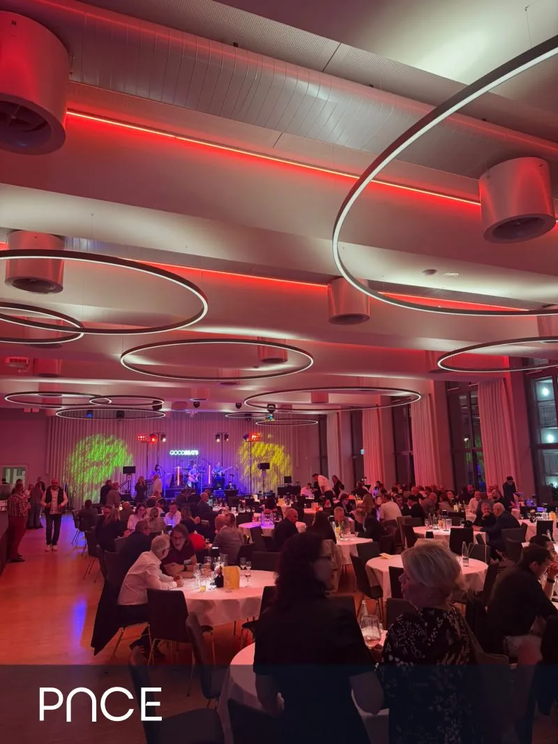 The conference evening: guests at round tables in front of a stage with a live band